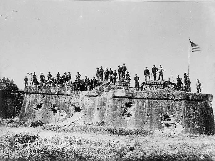 Victorious American soldiers atop a rampart in Intramuros.