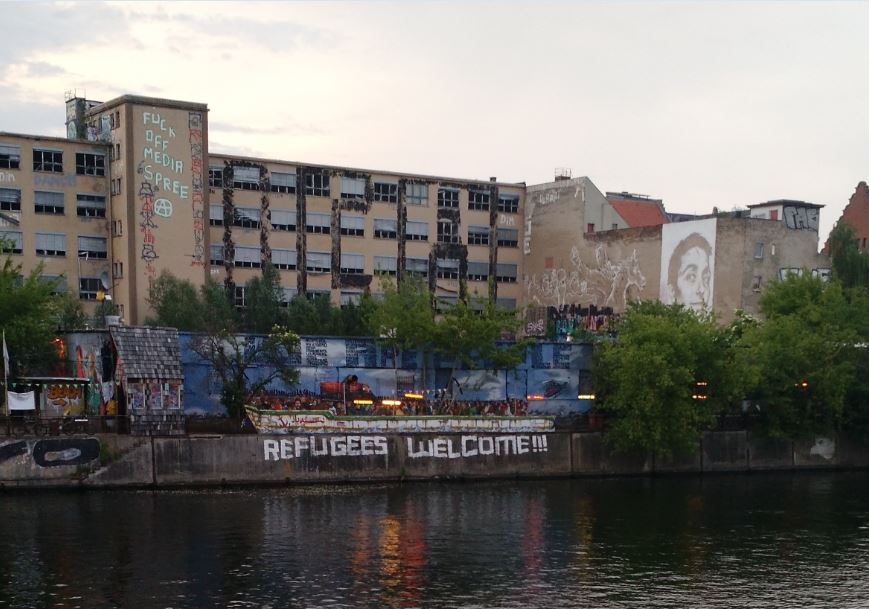 Graffiti on the Spree River welcomes Syrian refugees to Berlin.