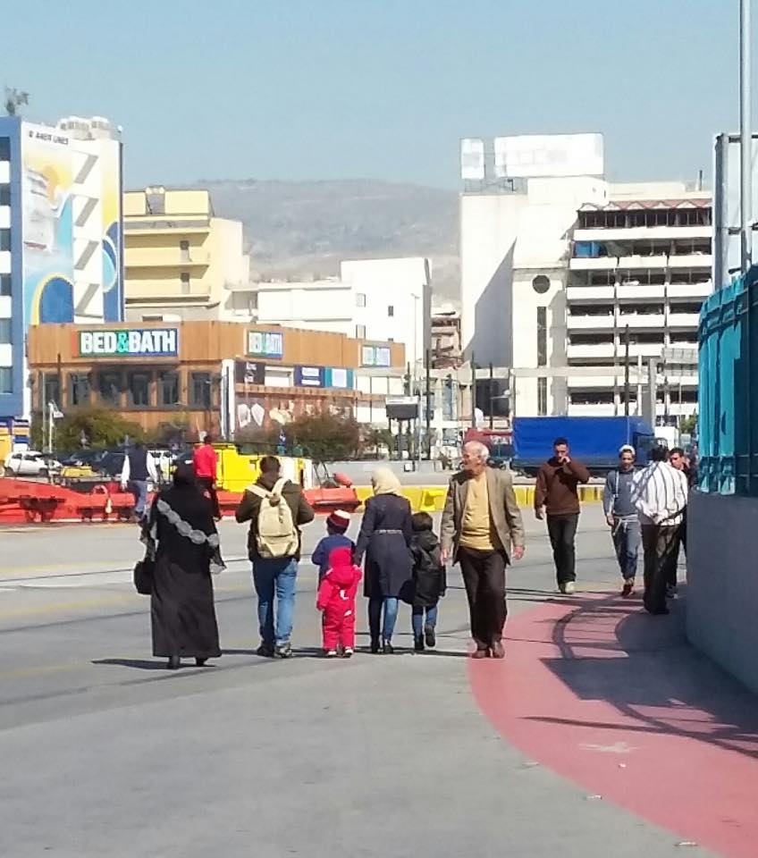 A refugee family walking around the perimeter of the port complex.