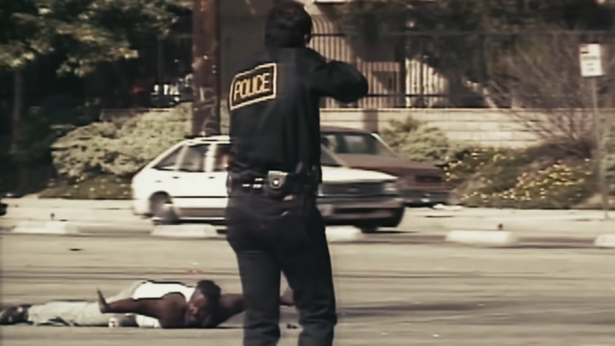 Police approach a man on the ground during the Los Angeles riots.