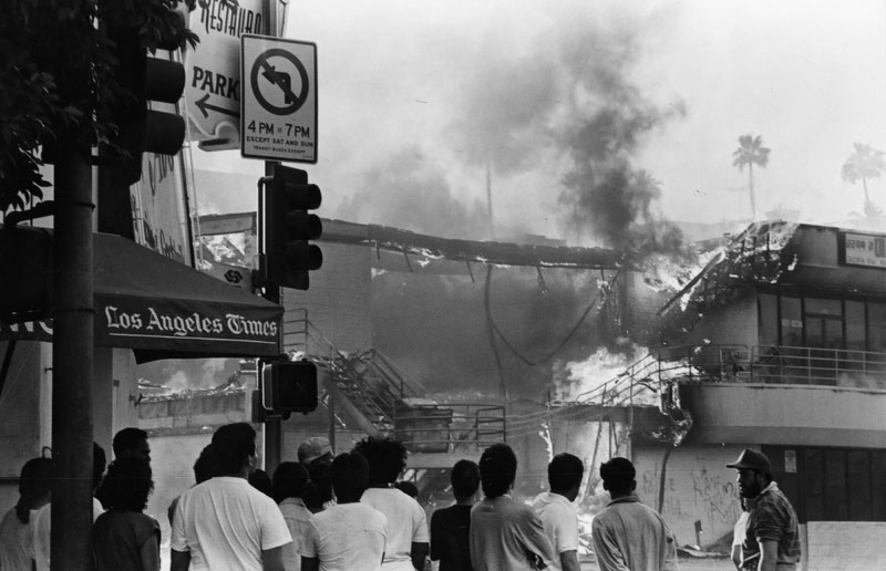 Onlookers watch as a building burns, 1992.
