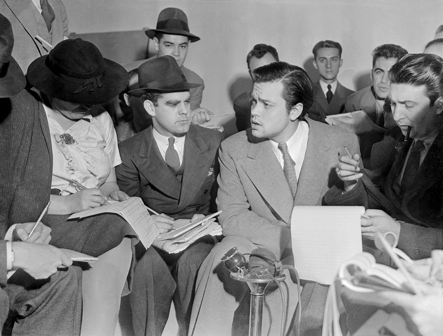 Welles speaking to assembled news reporters.
