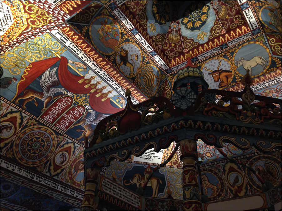Colorful ceiling decorated with Hebrew, animals, and zodiac symbols.