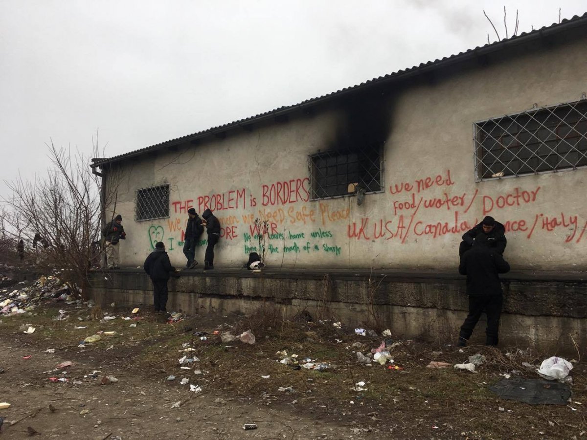 Refugees eating lunch outside the barracks.