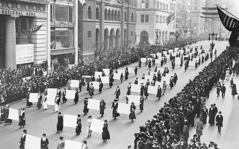 Suffragists carry placards displaying over one million New York women's signatures demanding the right to vote.