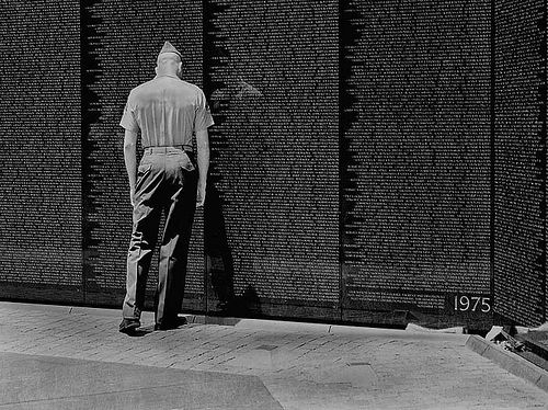 Soldier standing in front of the Vietnam War Memorial.