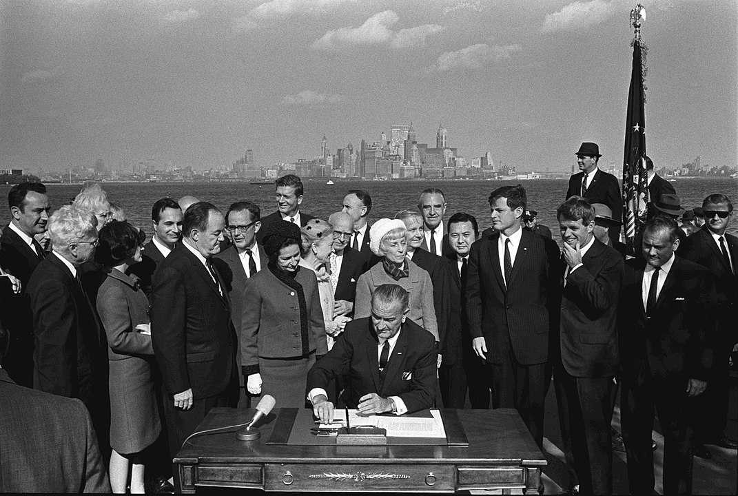 President Lyndon B. Johnson signs the Hart-Cellar Act of 1965.