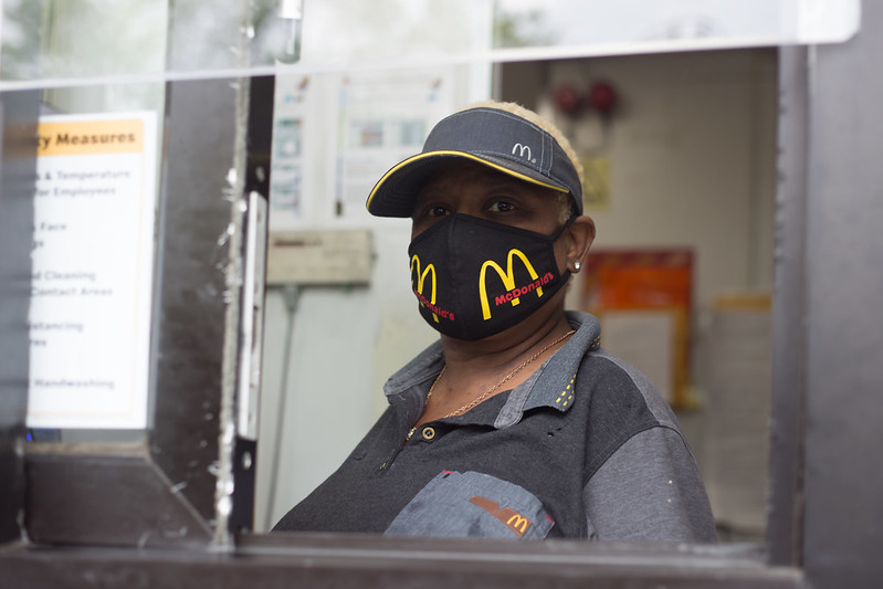 An essential McDonald's employee dons a company face mask.
