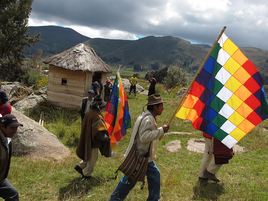 A traditional Aymara ceremony on the border of Lake Titicaca in Bolivia. The flag is the Wiphala, an emblem used to represent some native peoples of the Andes