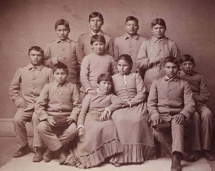 A group of Apache Native American children pose for a portrait.