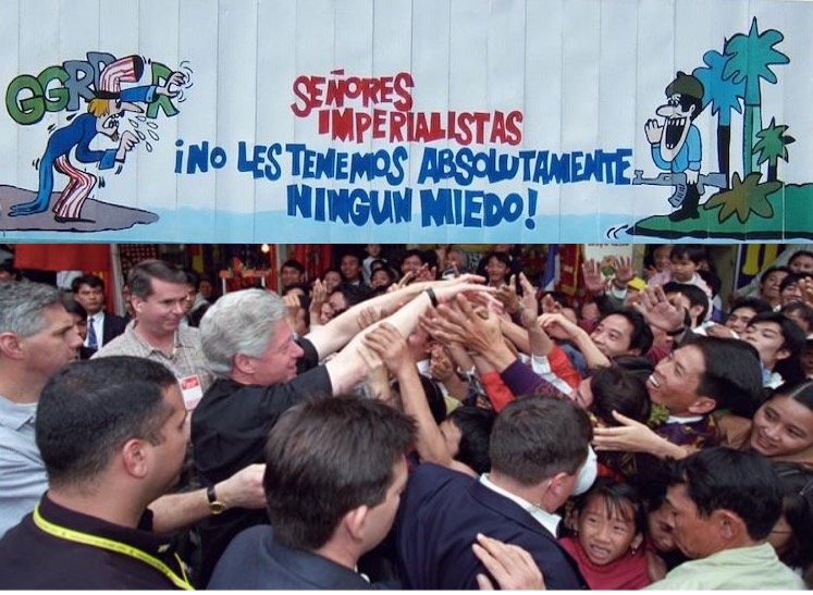 On the top, a 2005 billboard across the street from the U.S. Interests Section offices in Havana, Cuba. The Cuban soldier calls out to the aggressive Uncle Sam, 'Imperialist Sirs, we have absolutely no fear of you!' On the bottom, President Bill Clinton visiting Hanoi in 2000 after normalization of relations between the U.S. and Vietnam.