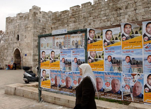 A woman in 2006 walking by Palestinian Parliamentary Election posters.