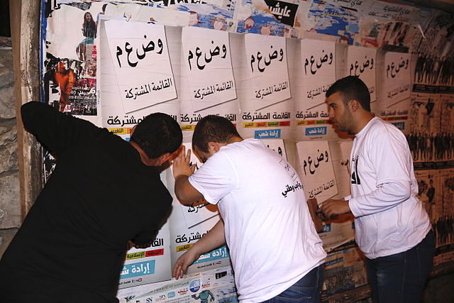 Joint List supporters hang campaign posters during the 2015 elections.