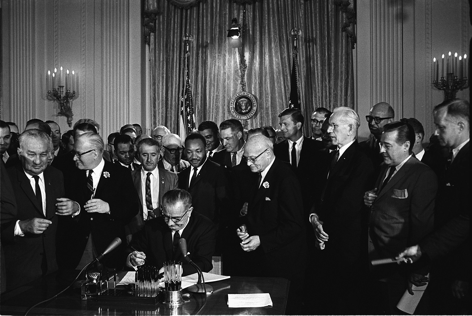 Lyndon B. Johnson signs the Civil Rights Act of 1964. Among the guests behind him is Martin Luther King, Jr.