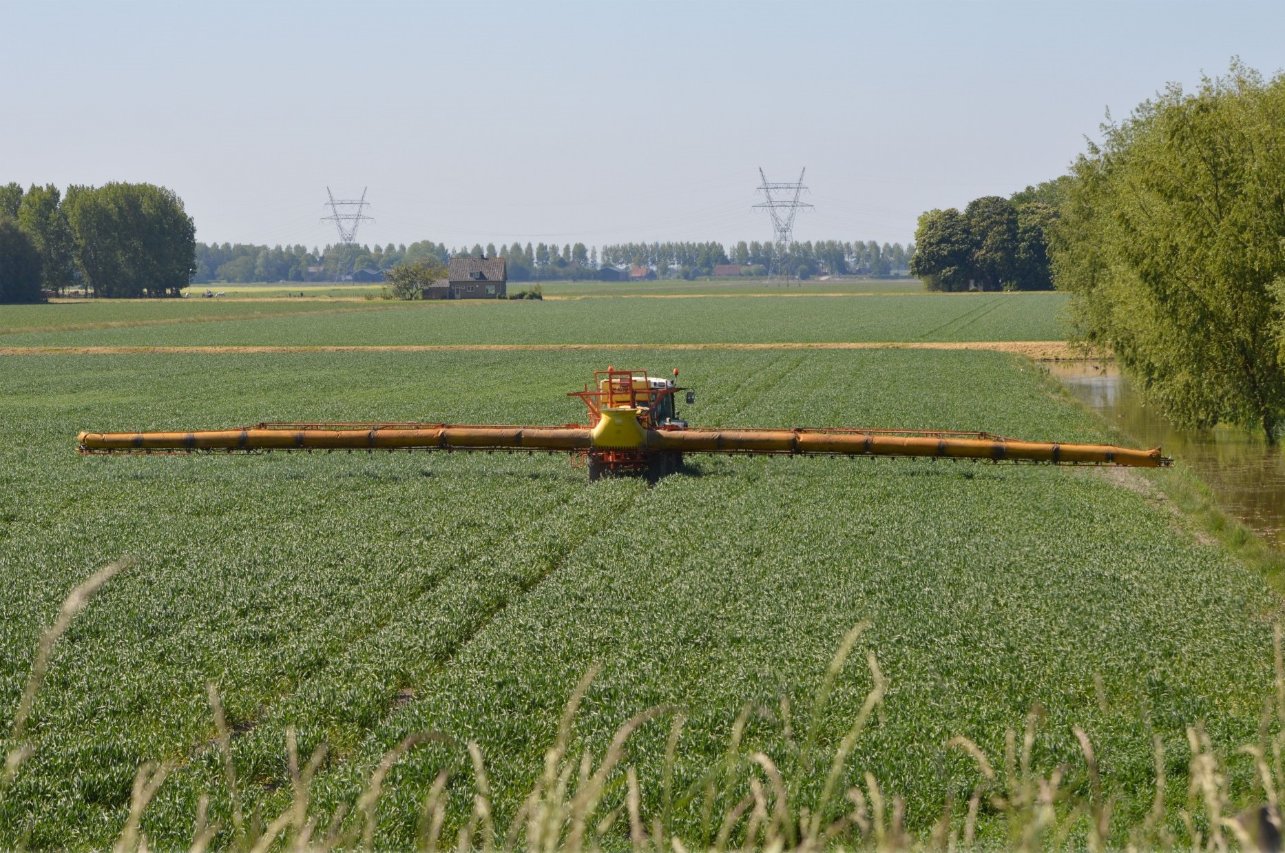 An industrial farm spraying pesticide on crops.