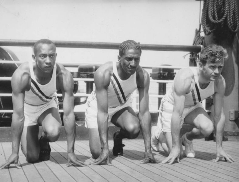 Ralph Metcalfe (center) with Jesse Owens (left) and Frank Wykoff (right) on the deck of the S. S. Manhattan as the team sailed for Germany ahead of the 1936 Olympics