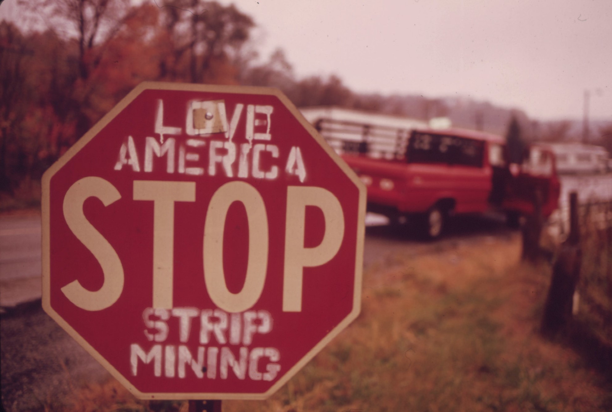 A stop sign in Southeastern Ohio spray-painted in opposition to constant strip mining and depletion of natural resources, 1973.