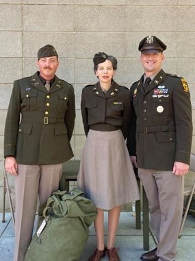 Modern-day reenactors (left and center) wearing the World War II Pinks-and-Greens Class A uniforms and an active duty U.S. Army Officer wearing the newly issued Army Green Service Uniform.
