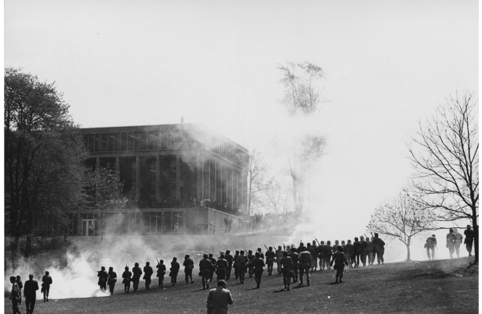 Ohio National Guardsmen fire tear gas at Kent State students.