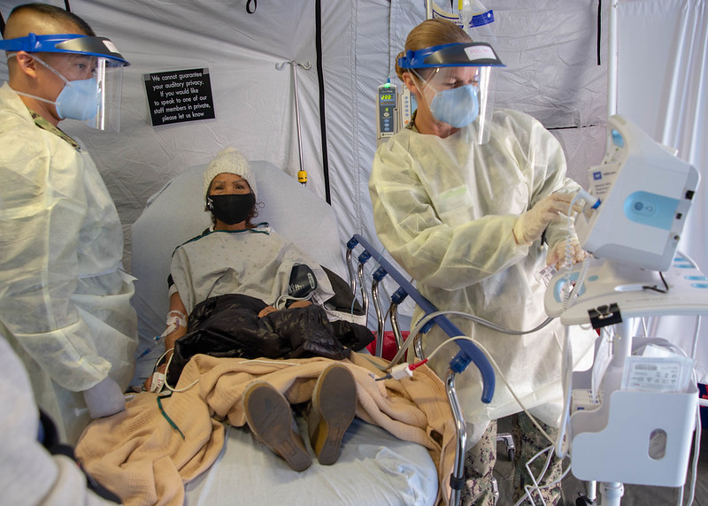 Lt. Cmdr. Raben Talvo (left), and Hospital Corpsman 1st Class Angela Ramirez (right) administer the San Diego Naval Medical Center's first monoclonal antibody (mAb) treatment to a COVID-19-positive patient, January 26, 2021