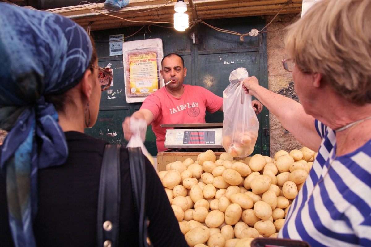 Jewish women pay for their produce at the Shuk.