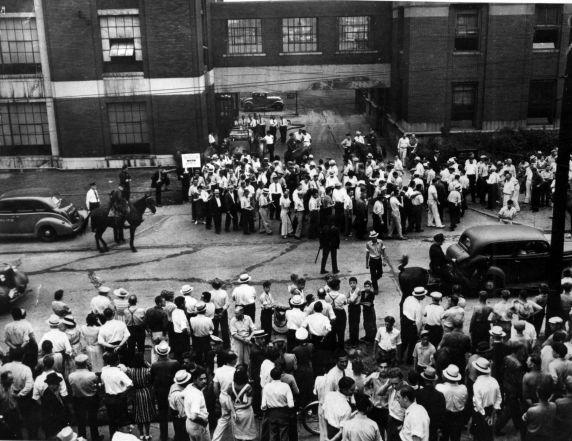 Strikers outside a GM plant with police standing guard in Flint, MI in 1937.