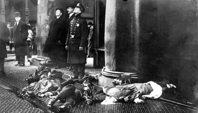 Onlookers watching the Triangle Shirtwaist Factory burn next to the bodies of those who jumped to escaped the fire.