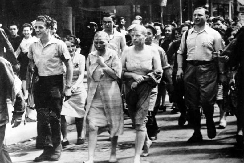 French women accused of having slept with Germans are paraded through the streets of Paris with their heads shaved and swastikas painted on their faces, summer 1944.