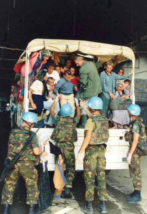 Dutch UNPROFOR soldiers help Bosniak refugees board a jeep in July 1995.