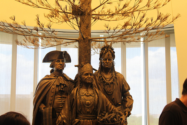 The Allies in War, Partners in Peace statue features the Oneida chief Shenendoah, the Oneida woman Polly Cooper, and George Washington standing under a towering White Pine tree.