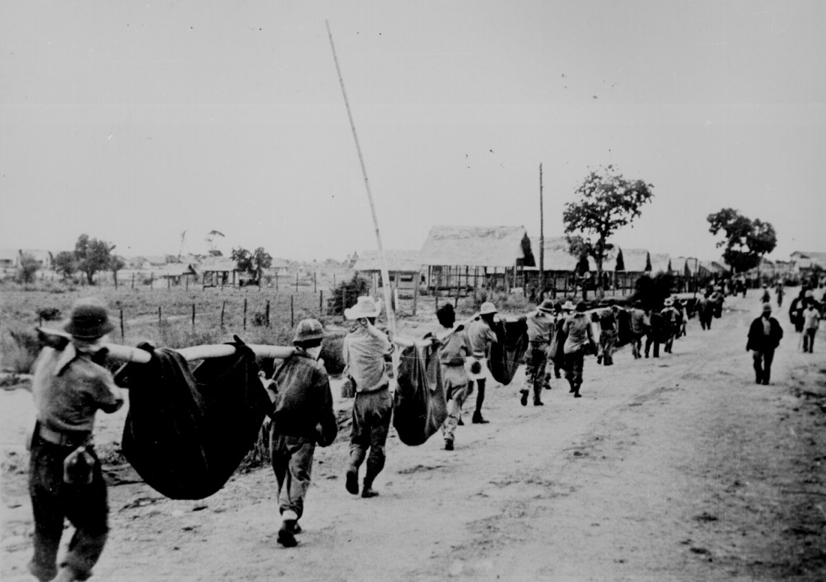 American prisoners use improvised litters to carry comrades too weak to walk along the road