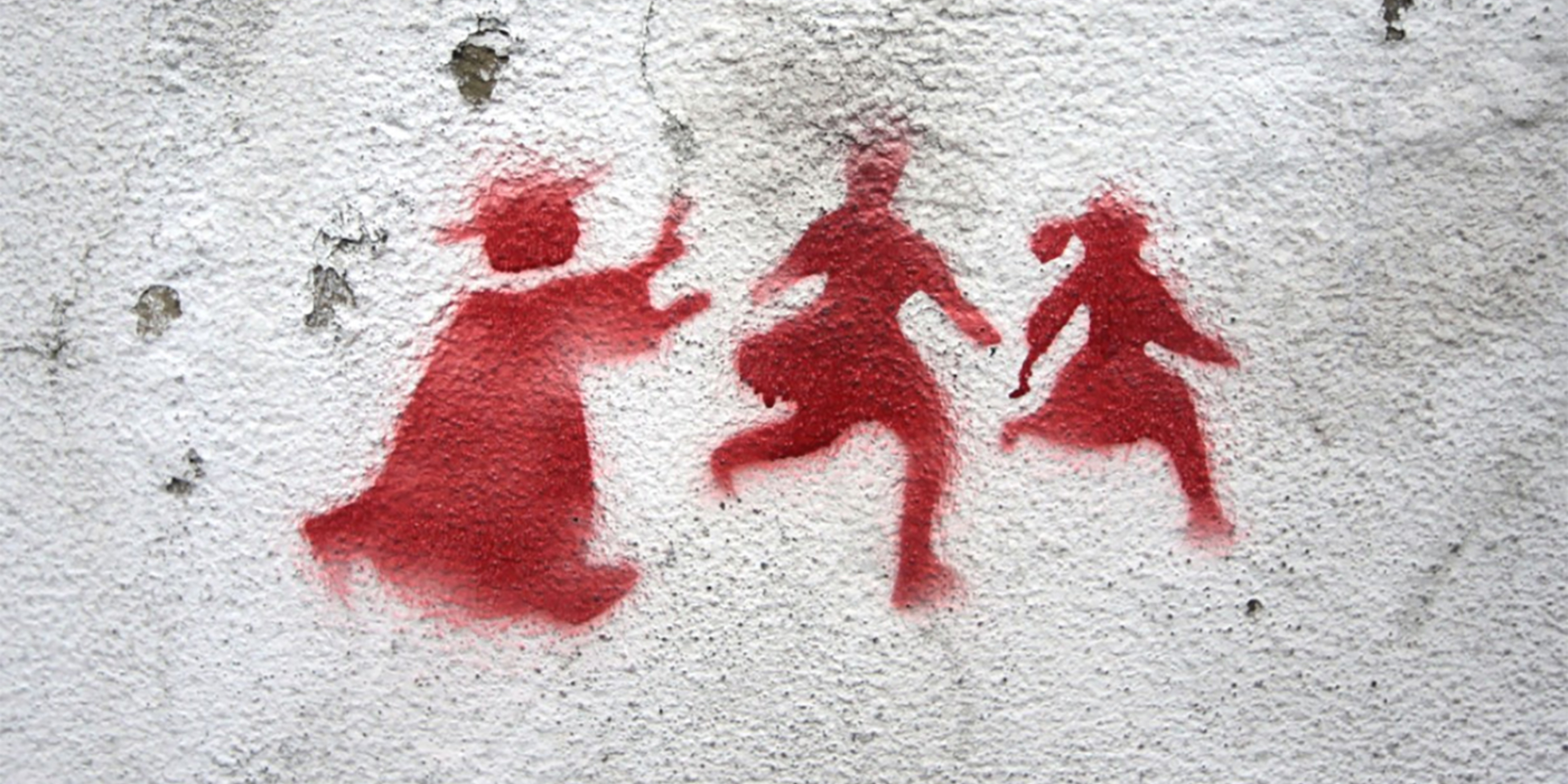 Stenciled graffiti of a priest pursuing two children