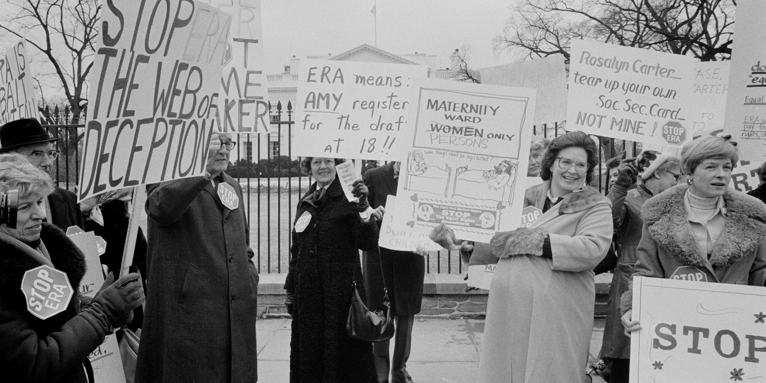 Group of women protesting against the ERA with signs: "Stop the web of deception," "ERA means Amy register for the draft at 18," "Maternity ward - persons only" 
