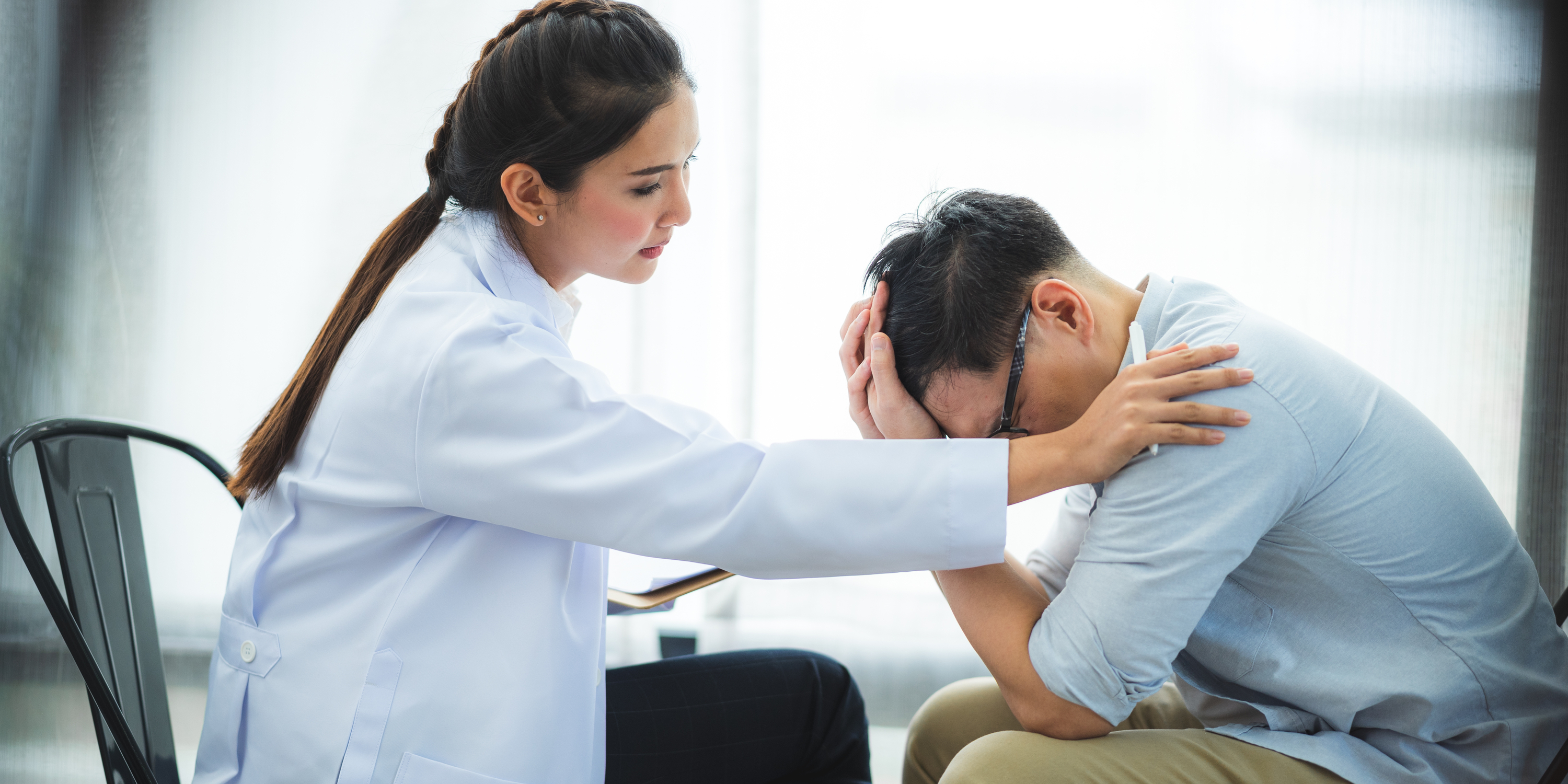 close up of psychologist with hand on male patient