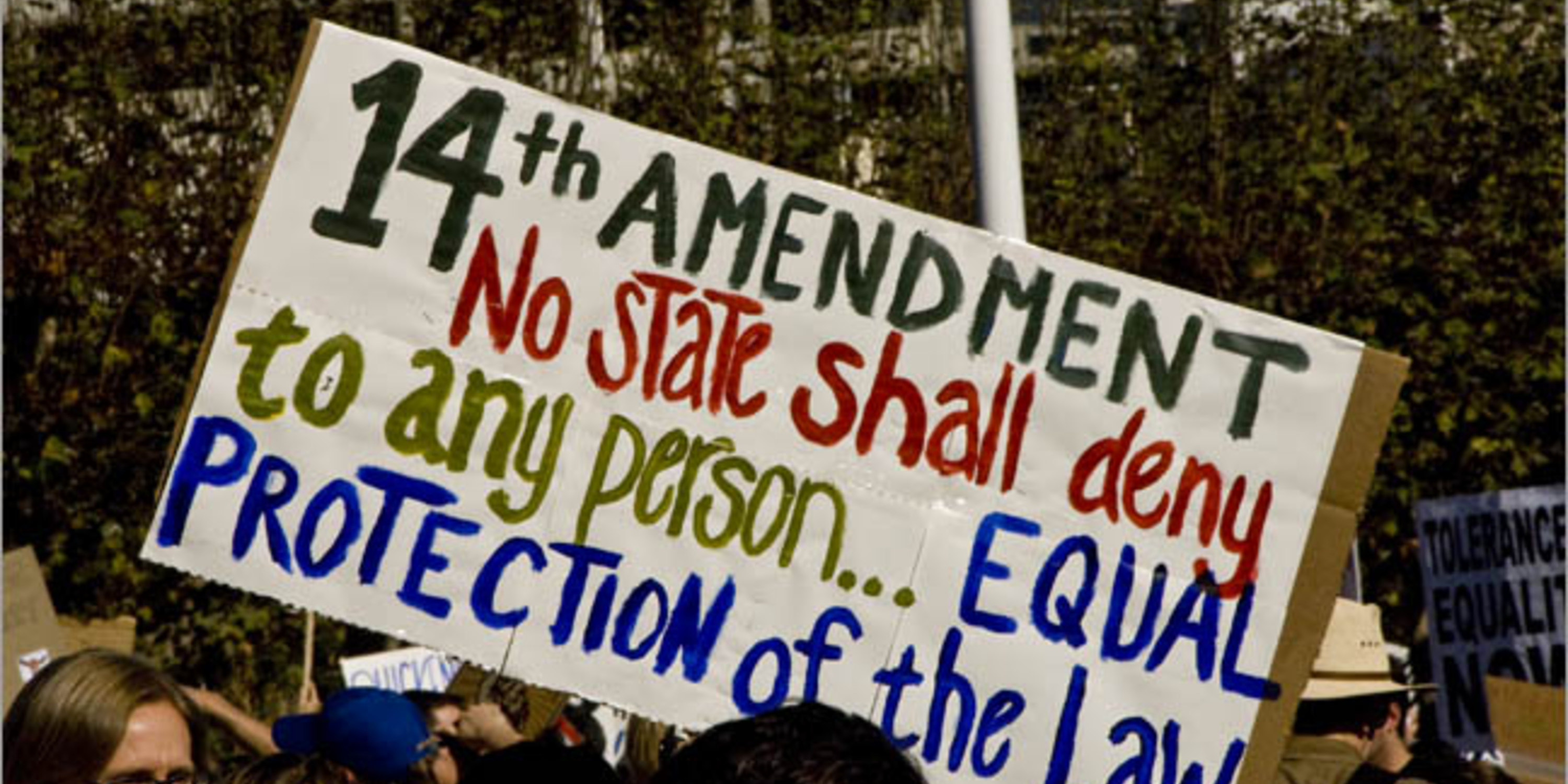 people holding sign that says 14th amendment no state shall deny to any person... equal protection of the law