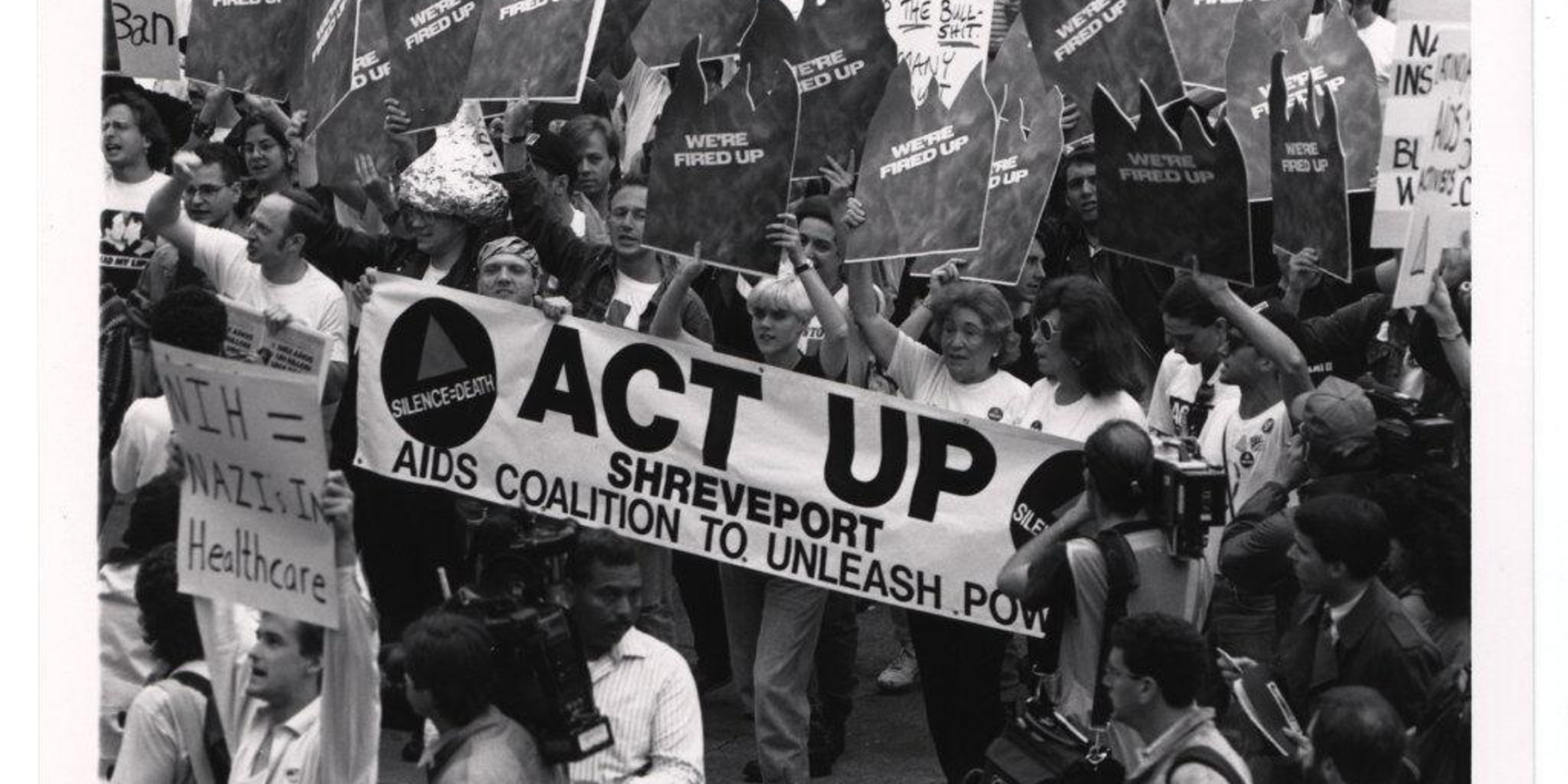 people holding banner that reads ACT UP Shreveport AIDS coalition to unleash power