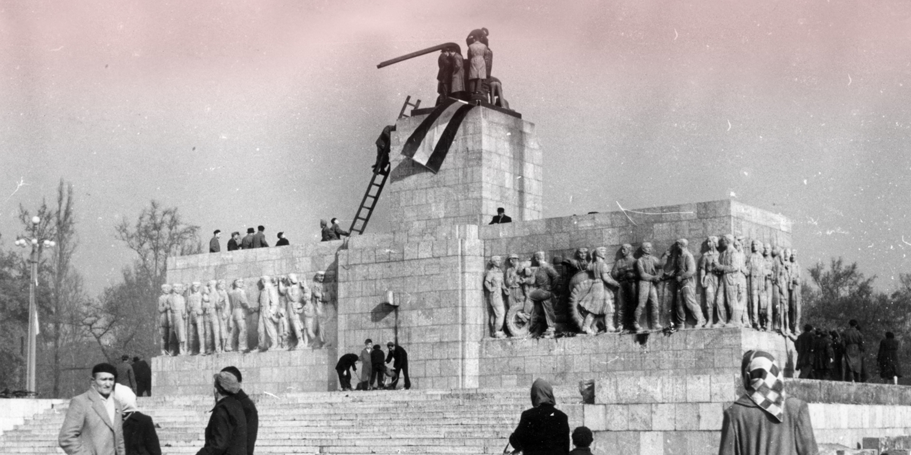 anti-communists and nationalists place a Hungarian national flag atop a demolished statue of Josef Stalin