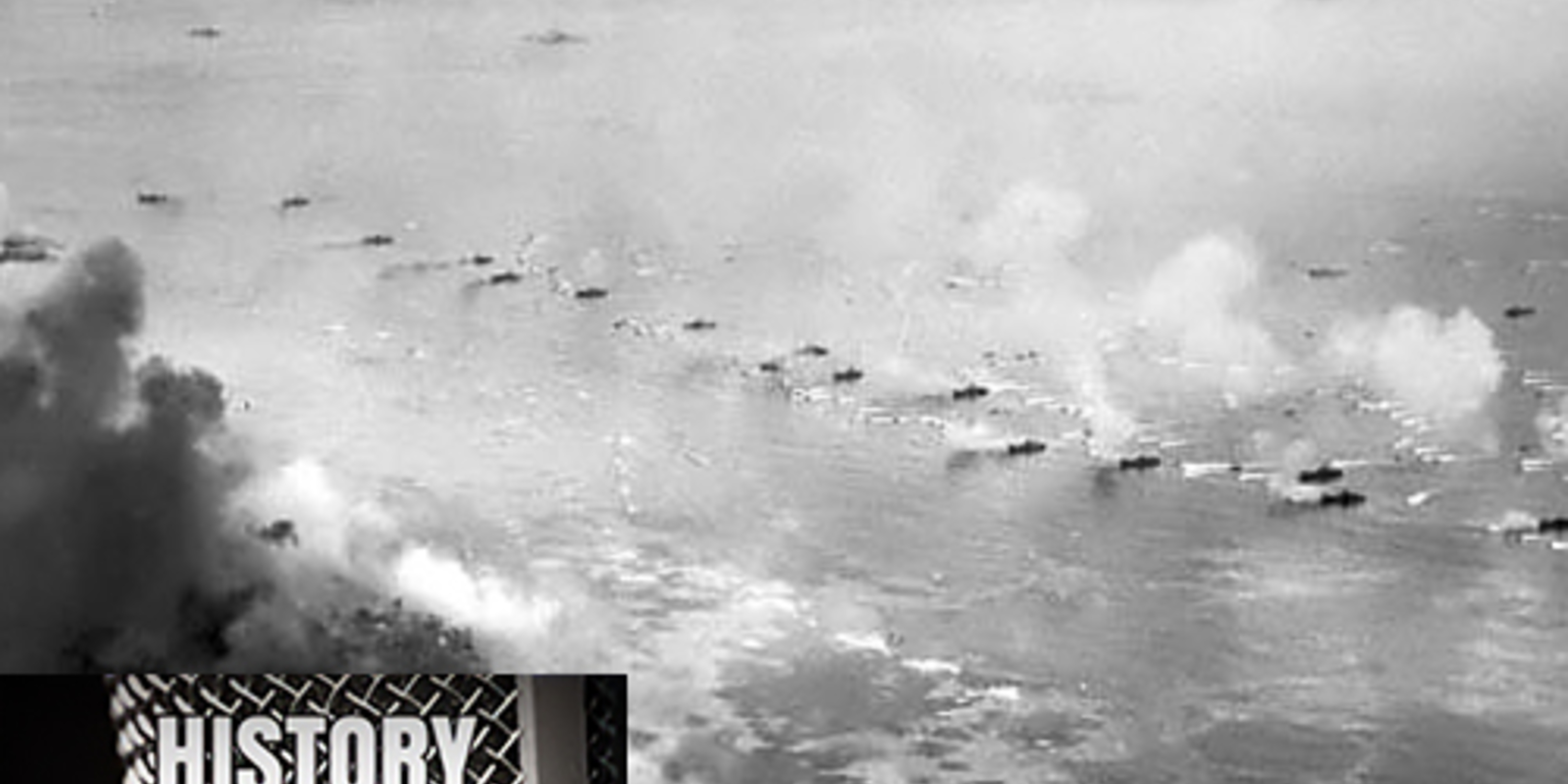 Black and white aerial photo of U.S. Marine boats approaching shore as smoke fills the air during the invasion of Peleliu