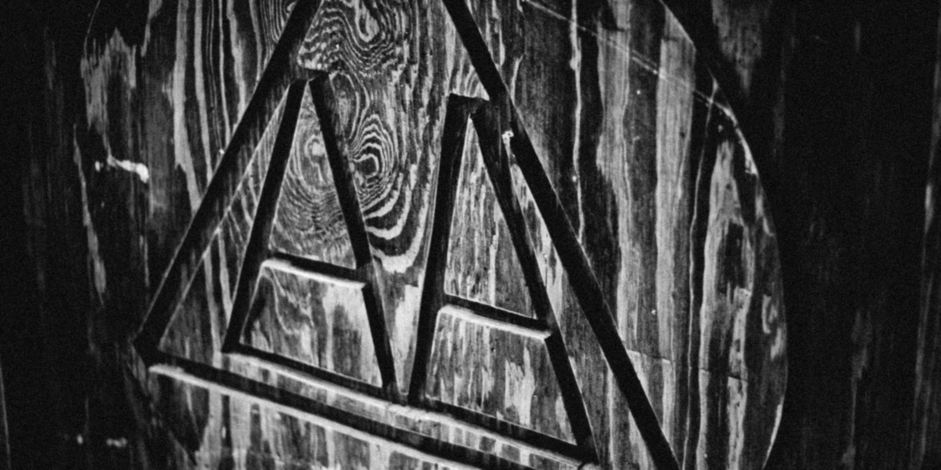 Black and white photo of the Alcoholics Anonymous logo carved into a wooden plaque