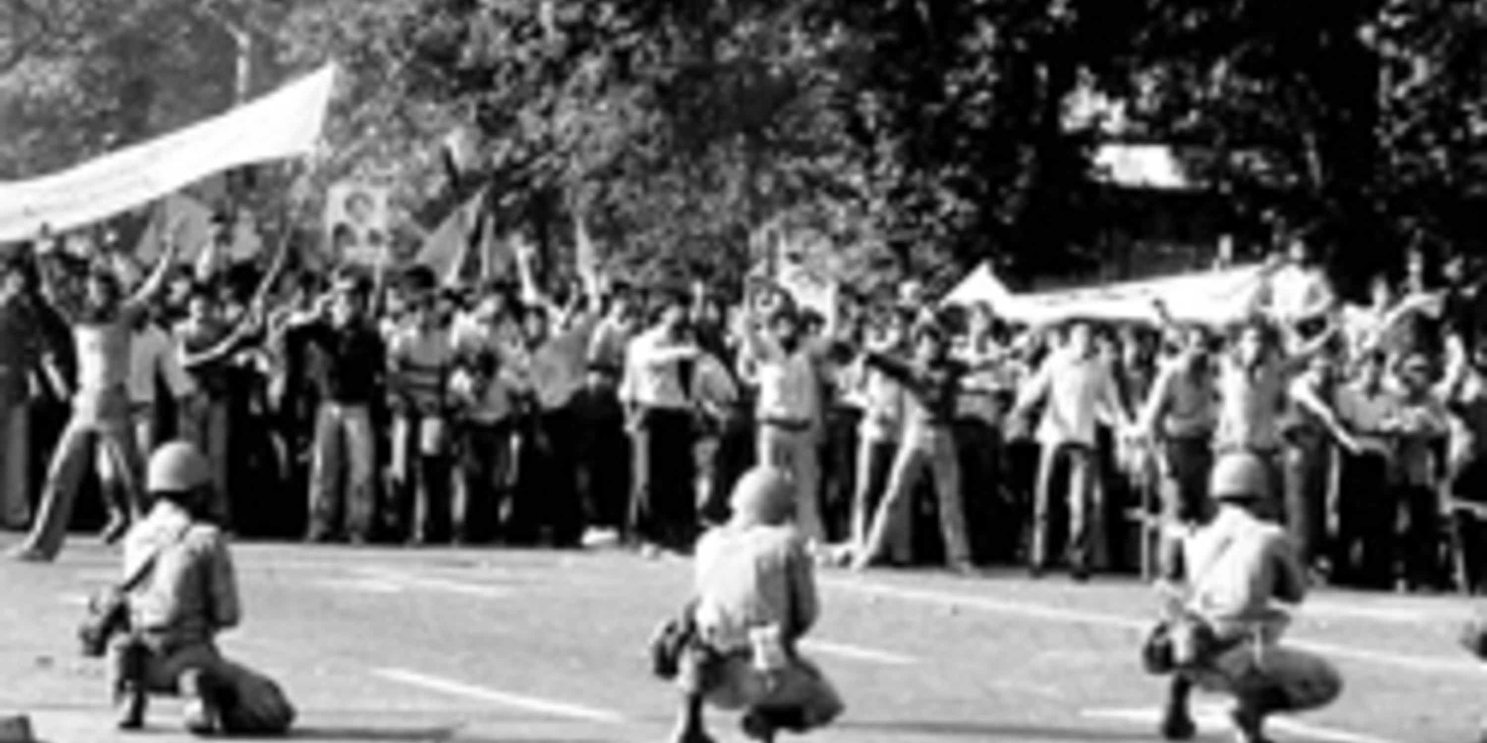 a protest in Iran - armed military hold guns on citizens