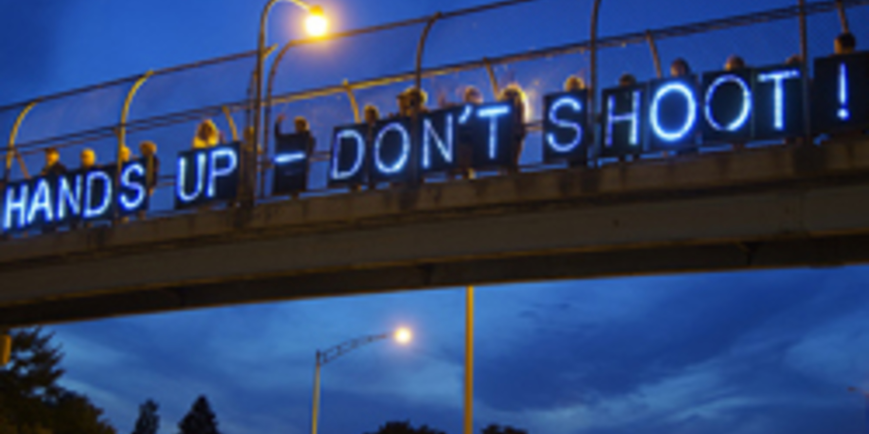 sign on bridge that states - hands up dont shoot