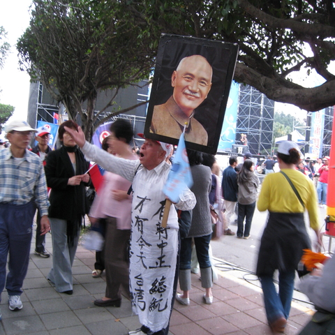 Thirty-two years after his death, Chiang Kai-shek is still a KMT standard-bearer. The white apron reads in part “Because we had President Chiang, therefore we have Taiwan today.”