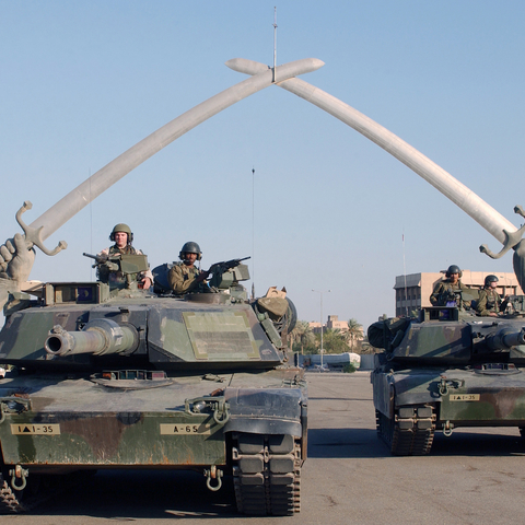 Members of the U.S. Army pose under the 'Hands of Victory' sculpture.