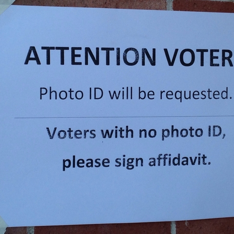 A sign warning of the photo ID requirements to vote.