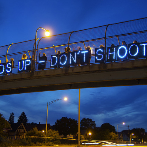 An August 2014 'Light Brigade' stands with Michael Brown near Red Arrow Park, Milwaukee.