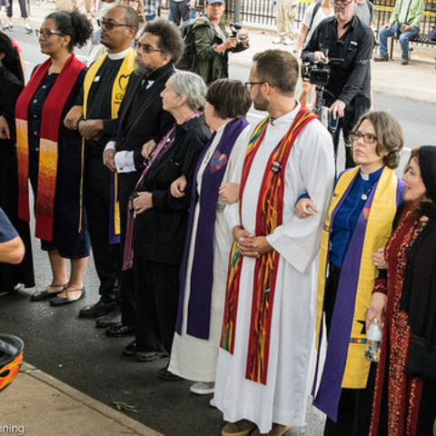 Clergy and other counter-protesters linking arms against protesters during the Unite the Right rally.