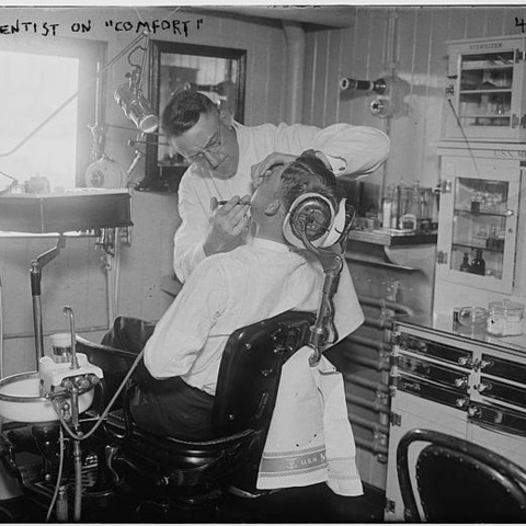 A dentist and patient in the 1910s or 1920s.