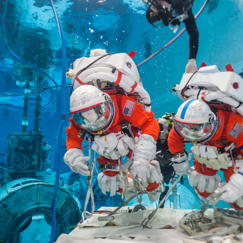 Astronauts practicing microgravity techniques.