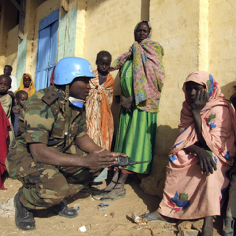 Member of the military component of the United Nations-African Union Hybrid Mission in Darfur (UNAMID) speaks with one of the villagers during a patrol routine.