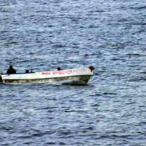 An armed suspected pirate looks over the edge of a skiff, in international waters off the coast of Somalia. The vessel opened fire on the U.S. Navy after this picture was taken- November 2008  